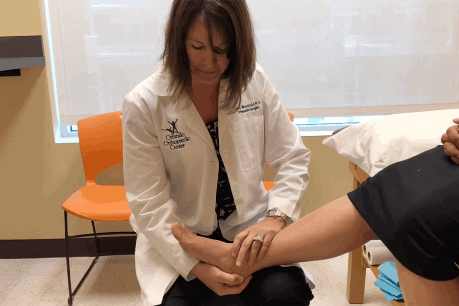 A specialist examines a patient for Total Ankle Replacement Surgery