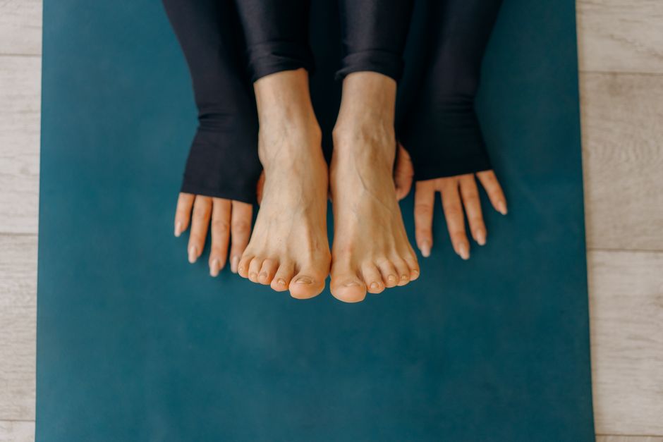 person stretching foot on a mat